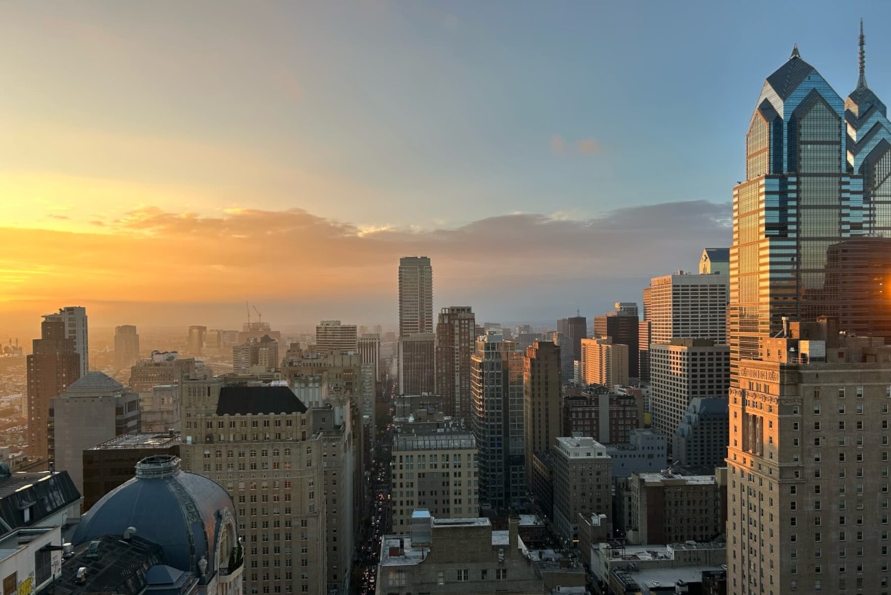 Philadelphia-Skyline bei Sonnenuntergang, Hochhäuser und gläserne Türme im warmen Abendlicht über der Stadt.