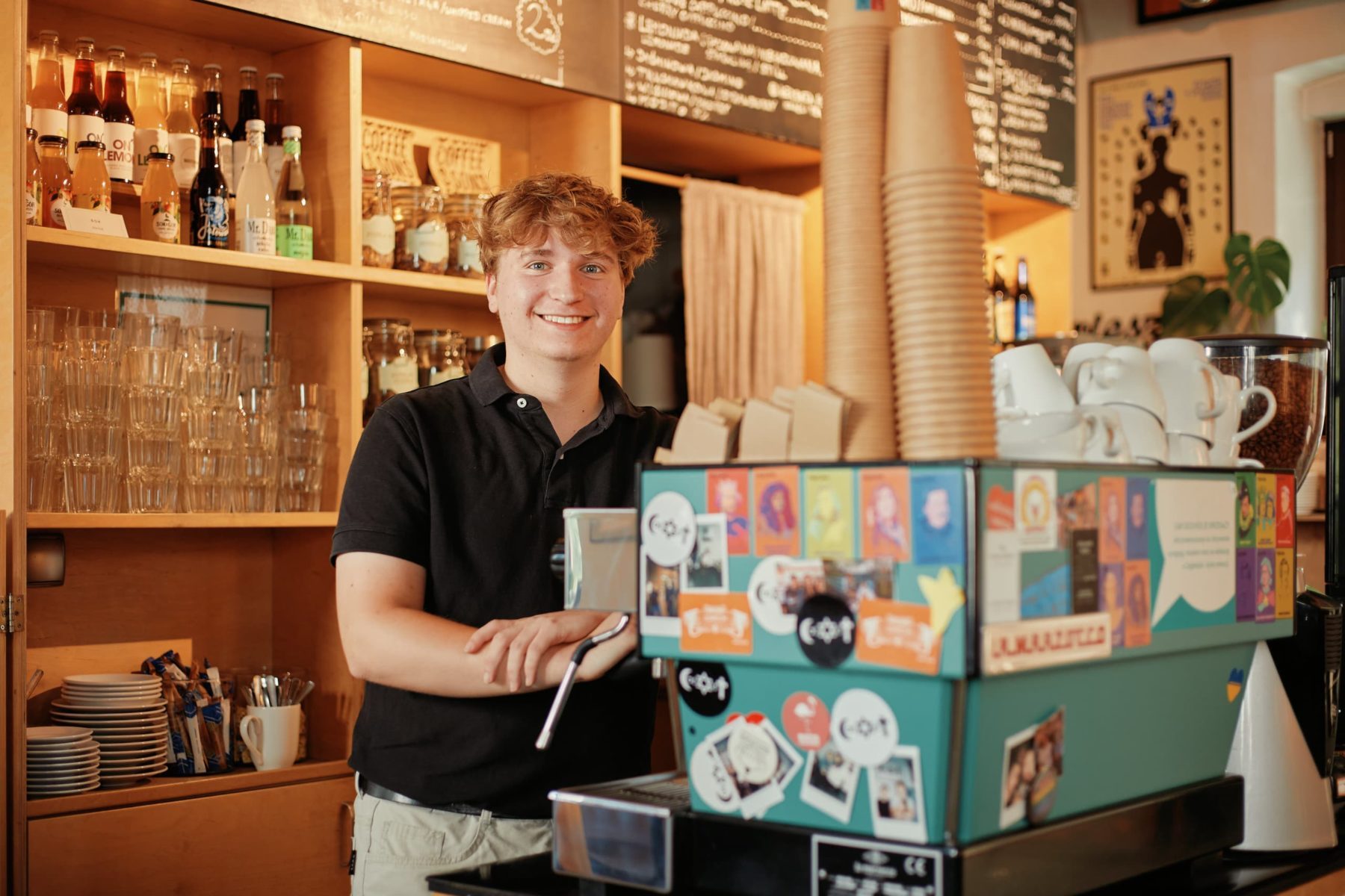 Ein Freiwilliger steht hinter einer Kaffeemaschine in einem Café in Oświęcim, Polen.