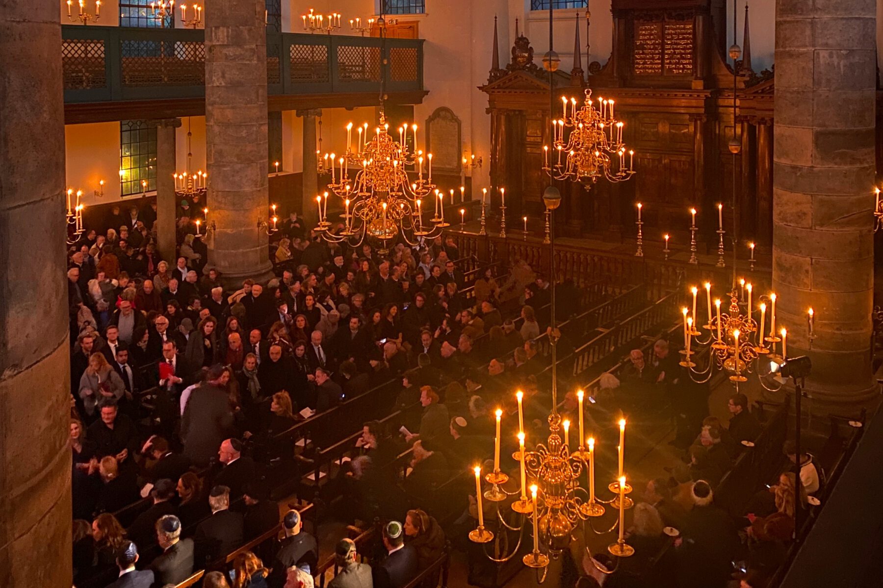 Kristallnacht-Gedenken Joods Cultureel Kwartier Amsterdam: Kerzenbeleuchtete Synagoge mit Kronleuchtern und vielen Gästen